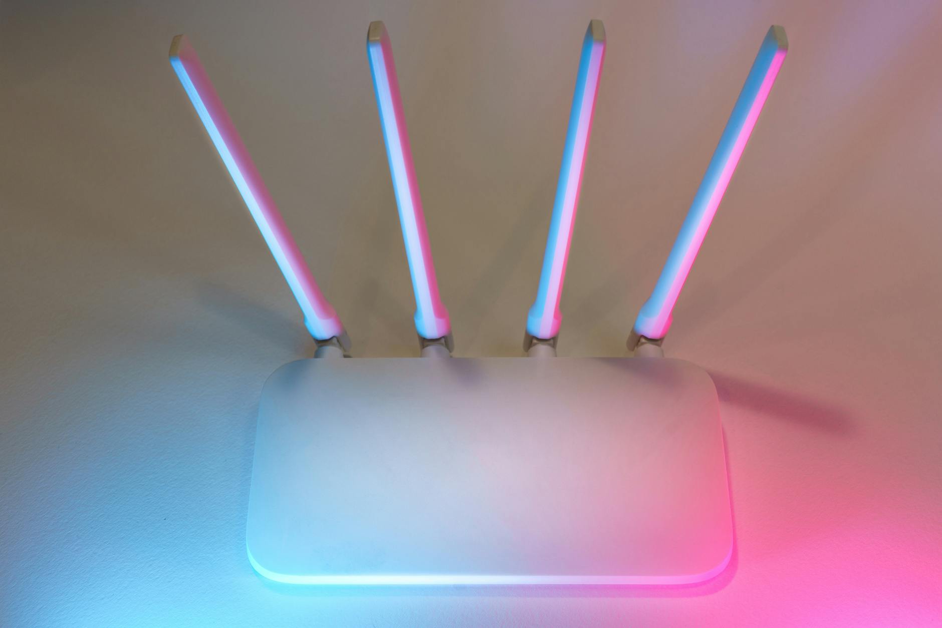 Nowoczesny biały router Wi‑Fi z czterema antenami i kolorowym podświetleniem