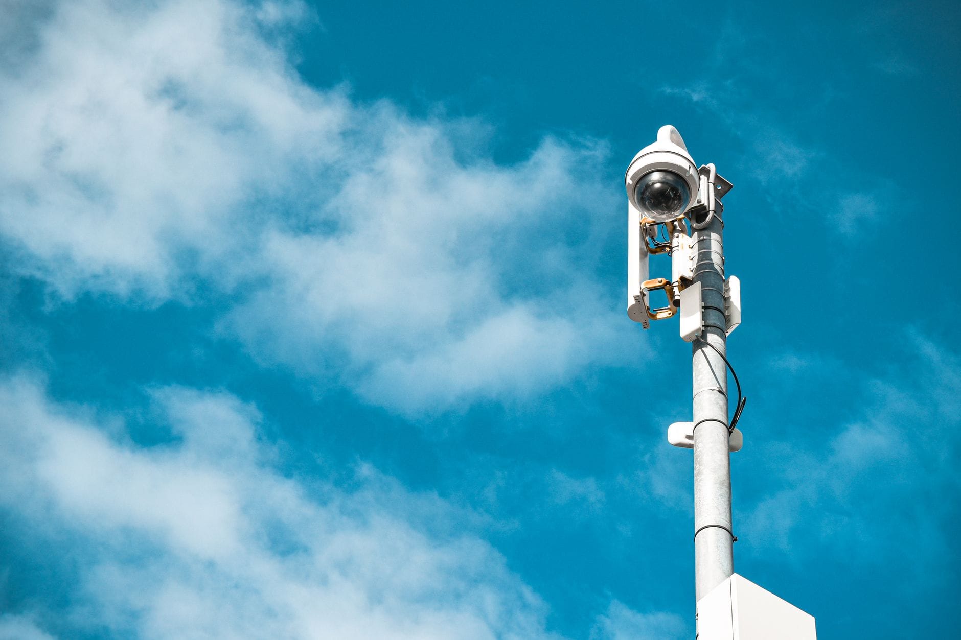Kamera monitoringu na słupie na tle czystego nieba