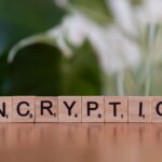 Jak AI pomaga łamać i wzmacniać szyfrowanie: aktualne trendy w kryptografii i cyberbezpieczeństwie Drewniane klocki układające napis encryption w zbliżeniu