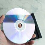 Jak zaplanować backup środowiska CI/CD w chmurze i odtworzyć je po awarii Osoba trzymająca odblaskową pł